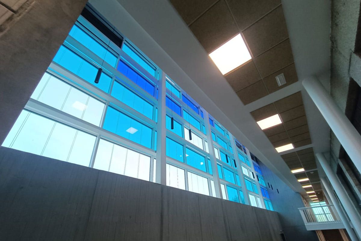 Vista interior al muro cortina de vidrio fotovoltaico de silicio cristalino y amorfo de Onyx Solar para la UCAV Labs 